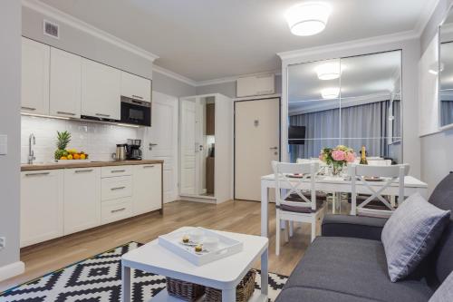 a kitchen and living room with a table and a couch at Horyzont Luksusowe apartamenty nad morzem z parkingiem Międzyzdroje in Międzyzdroje