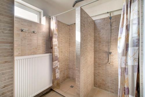 a bathroom with a shower and tiled walls at Óbudai Diákszálló in Budapest