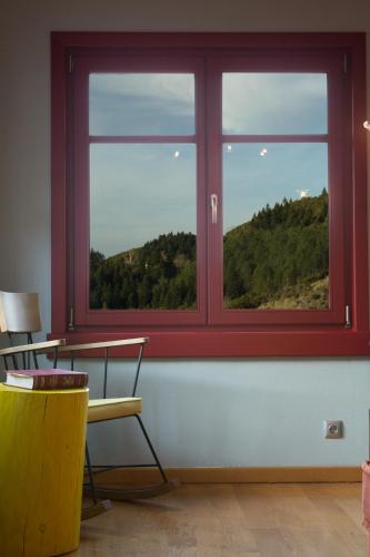 a room with a window with a table and chairs at Rouista Tzoumerka Resort in Vourgareli