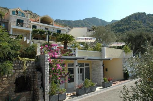 a house with flowers on the side of it at Apartments Balic in Sveti Stefan