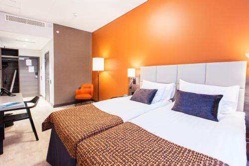a hotel room with two beds and a desk at Quality Hotel Winn Haninge in Haninge