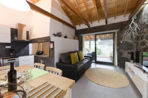 a kitchen and living room with a couch and a table at Casa Alto da Ladeira in Prainha de Baixo