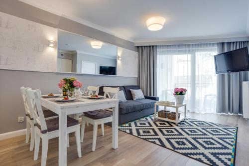 sala de estar con mesa y sofá en Horyzont Luksusowe apartamenty nad morzem z parkingiem en Międzyzdroje