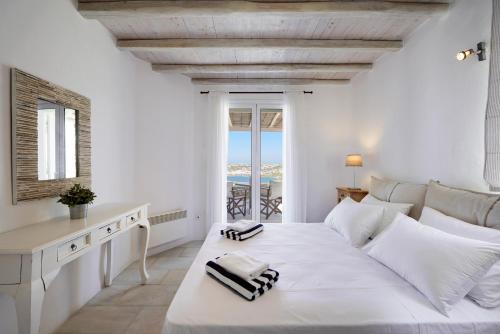 オルノスにあるNalu Villaの白いベッドルーム(大きな白いベッド1台、窓付)