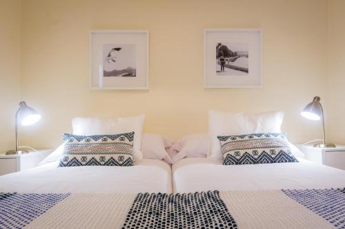 a bedroom with two beds and two lamps at Apartamento Urgul in Donostia-San Sebastián