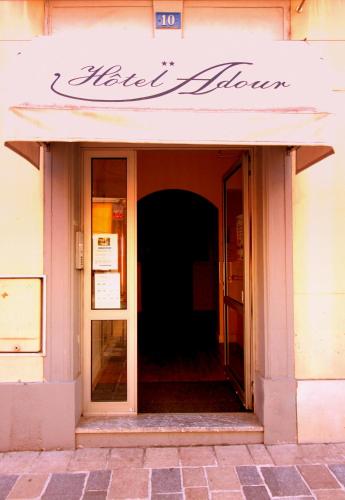 an entrance to a building with a sign on it at Hôtel Adour in Pau