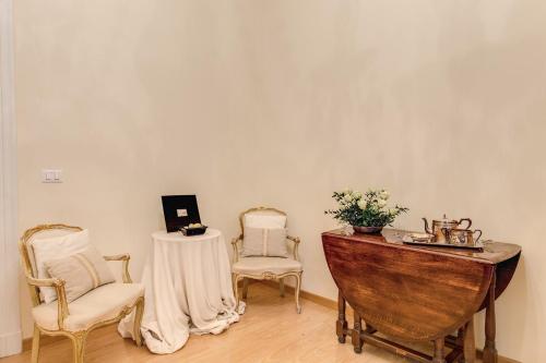 a room with two chairs and a table and a piano at RHH Rome Holiday Home in Rome