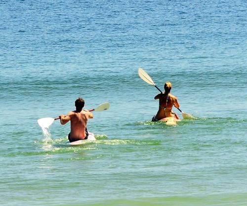 two people in the water with paddles in the water at 3 Dolphins in Britannia Bay