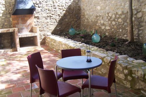 a table and chairs in a patio with a fireplace at Apartamentos Bergantes in Ortells
