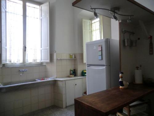 Il comprend une cuisine équipée d'un réfrigérateur, d'une table et de fenêtres. dans l'établissement Casa Pucci, à Pietrasanta
