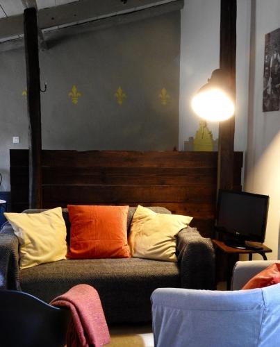 a couch with colorful pillows in a living room at La Blanchisserie in Le Puy-Saint-Bonnet