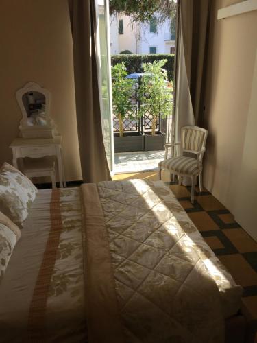 a bedroom with a bed and a chair and a window at Lucca Relais in Lucca