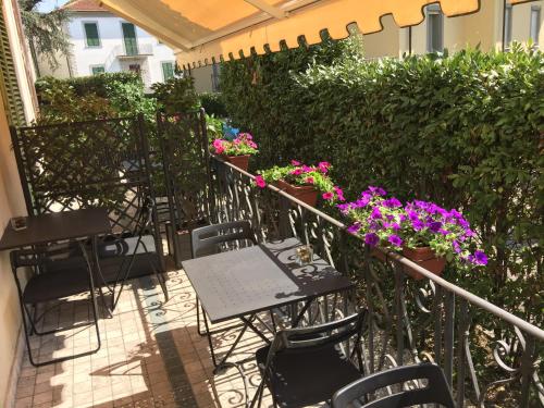 an outdoor patio with tables and chairs and flowers at Lucca Relais in Lucca