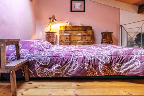 a bedroom with a purple bed and a wooden chair at Loft Duomo Firenze in Florence