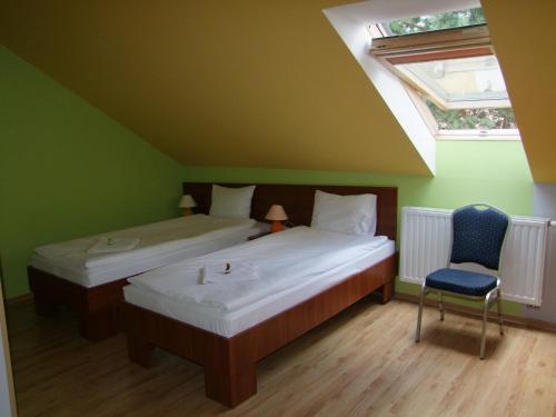 Dos camas en una habitación con ventana y silla. en Warneńczyka 85A bezpłatny parking, faktura, prywatna łazienka, klimatyzacja, en Rzeszów