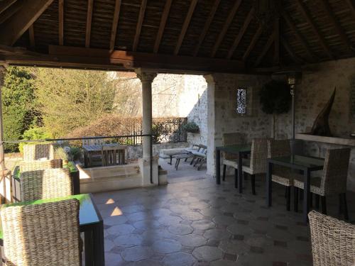 an outdoor patio with tables and chairs and a porch at Demeure des Vieux Bains in Provins