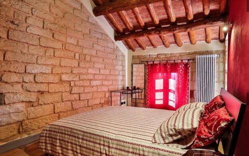 een slaapkamer met een bed en een bakstenen muur bij B&B Carletto in Cella Monte