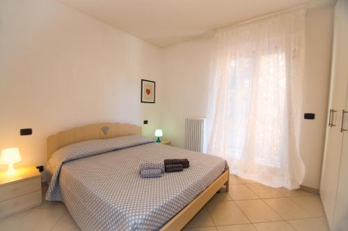 - une chambre avec un lit et une grande fenêtre dans l'établissement Bilocale Damiani a due passi dal mare, à San Benedetto del Tronto