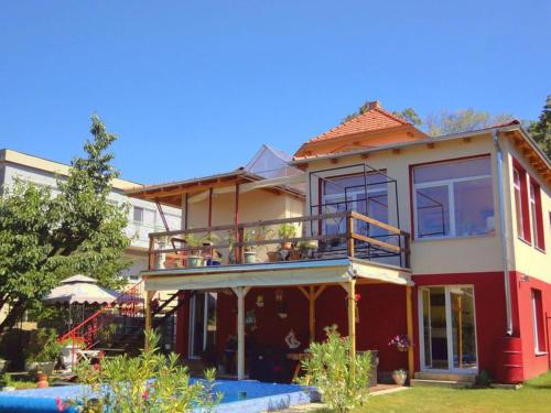 a house with a balcony and a pool at Villa Sonnenschein in H&eacute;v&iacute;z