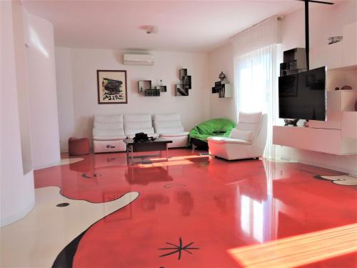 ein Wohnzimmer mit einem roten Boden in der Unterkunft Miro' Holiday Attic in Bologna