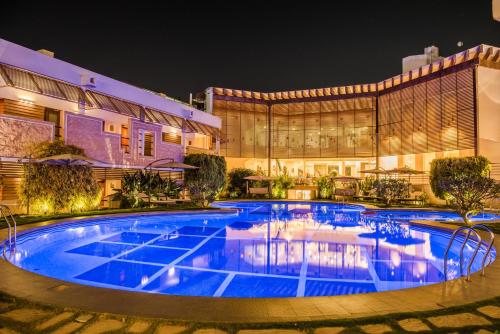 a swimming pool in front of a building at night at The Red Maple Mashal in Indore