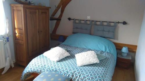 a bedroom with a bed with two pillows on it at Le Moulin Aux Moines in Croissy-sur-Celle