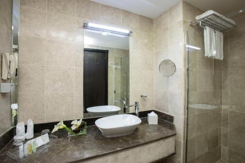 a bathroom with a sink and a mirror at The Town Hotel Doha in Doha