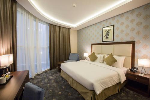 a hotel room with a large bed and a desk at The Town Hotel Doha in Doha