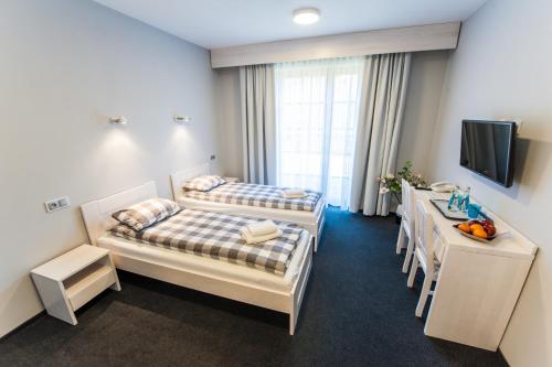 a hotel room with two beds and a table at Pensjonat Karczma Spalska in Spała