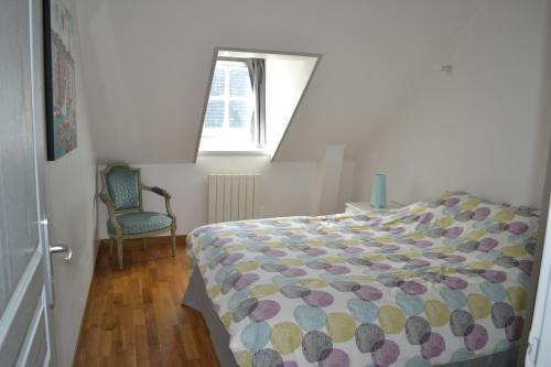 a bedroom with a bed and a window and a chair at appartement rue haute in Honfleur