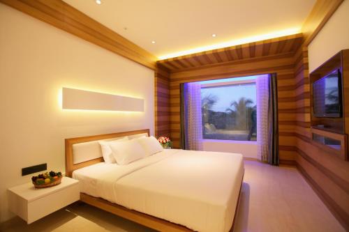 a bedroom with a white bed and a window at Diana Heights Luxury Hotel in Nedumbassery