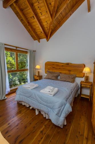 a bedroom with a bed with two towels on it at Cabañas Villa Sequoia in San Carlos de Bariloche