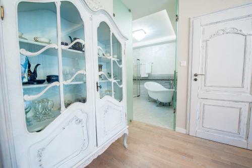 un armario blanco con puertas de cristal en el baño en Pensjonat Karczma Spalska, en Spała