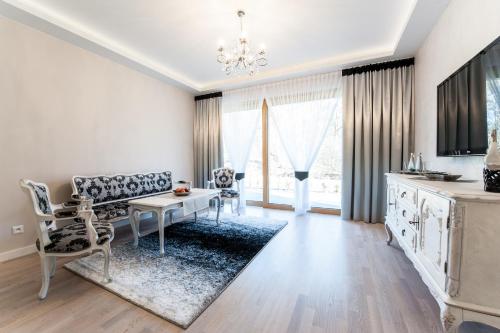 a white living room with a table and chairs at Pensjonat Karczma Spalska in Spała
