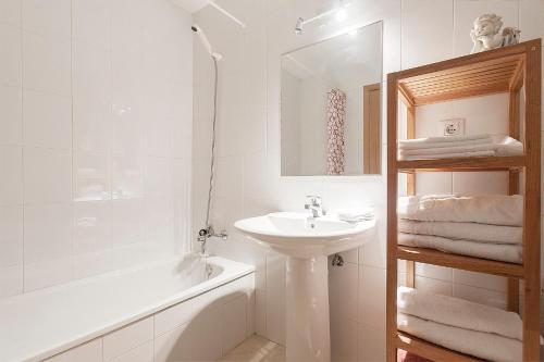 a white bathroom with a sink and a bath tub at Mia Beach-City apartment in Montgat