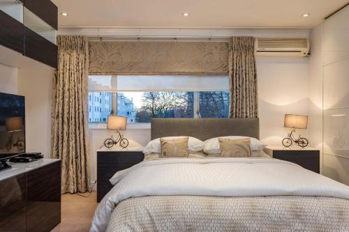 una camera da letto con un letto grande e una finestra di Hyde Park Residence a Londra