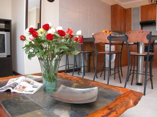 a vase of flowers and a pair of shoes on a table at Keret Accommodation in Bellville