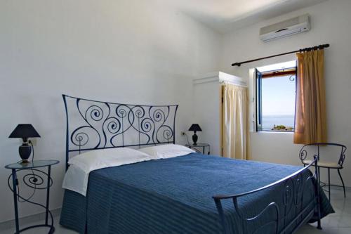 - une chambre avec un lit bleu et une fenêtre dans l'établissement Hotel Girasole, à Panarea