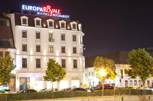 a large white building with a neon sign on it at Europa Royale Bucharest in Bucharest