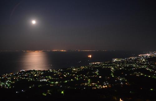 a full moon rising over the water at night at Sea Breeze Apartments Chios in Monolia