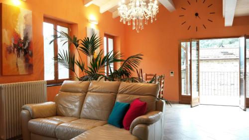 a living room with a couch and a clock on the wall at Casa Pablo in Badalucco