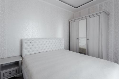 - une chambre blanche avec un lit et une armoire dans l'établissement City Center Apartment, à Odessa
