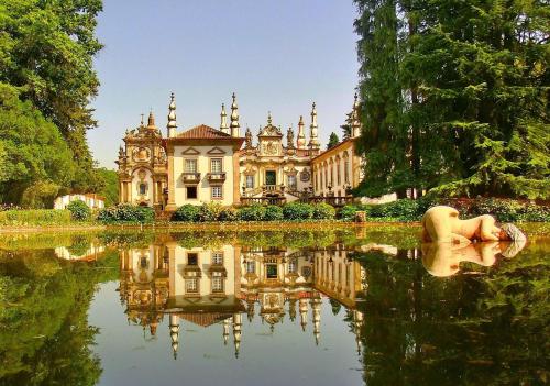a large house with a reflection in the water at Era Uma Vez Apartment in Vila Real