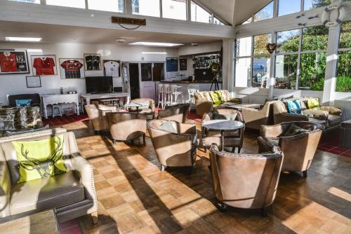 シドマスにあるThe Woodlands Hotelの椅子、テーブル、窓が備わる広い客室です。