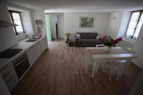a kitchen and living room with a table and a couch at Cà del fornello in Fosdinovo