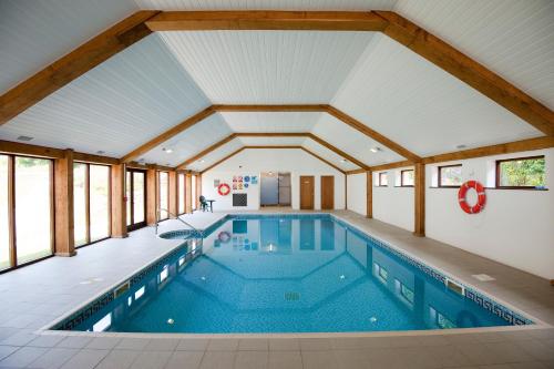 a pool in a house with a large ceiling at Green Acres Cottages in Par