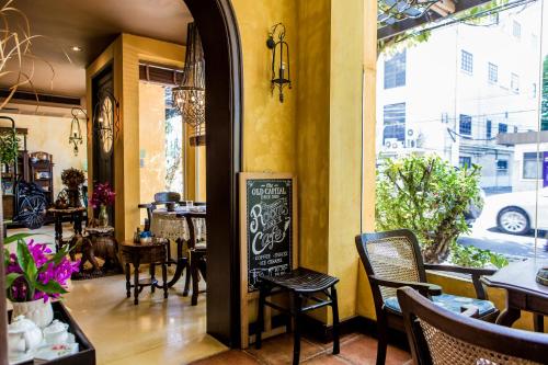 a restaurant with a chalkboard sign in a room with tables and chairs at Old Capital Bike Inn - SHA Certified in Bangkok