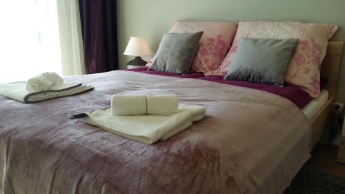 a bed with two folded towels on top of it at Apartment Krucza in Wrocław