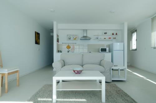 een woonkamer met een bank en een tafel bij Casa Rosa-Porto dos Carneiros in Lagoa