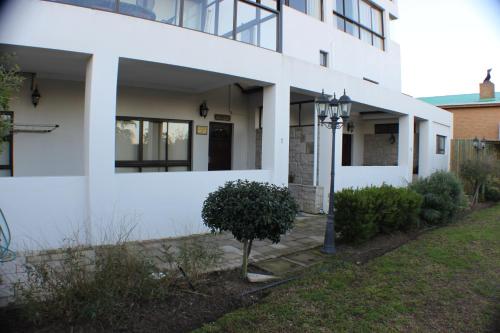 a white building with a tree in front of it at Keret Accommodation in Bellville